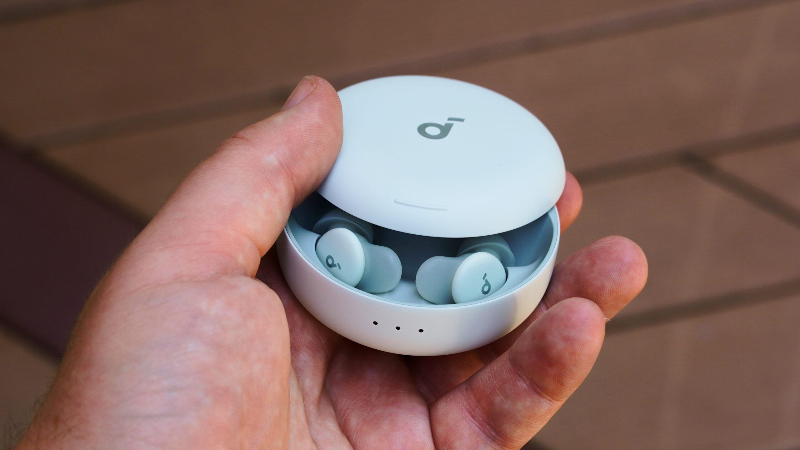 The Anker Soundcore Sleep A30 earbuds with the case half-opened in the hand.